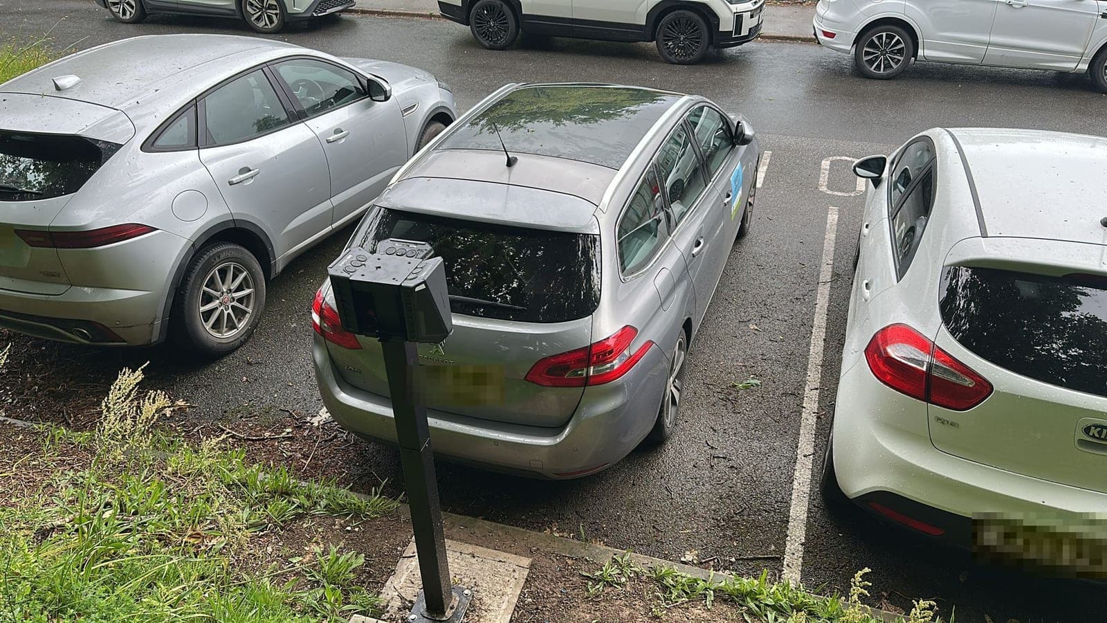 A charger post at the head of a staff parking bay
