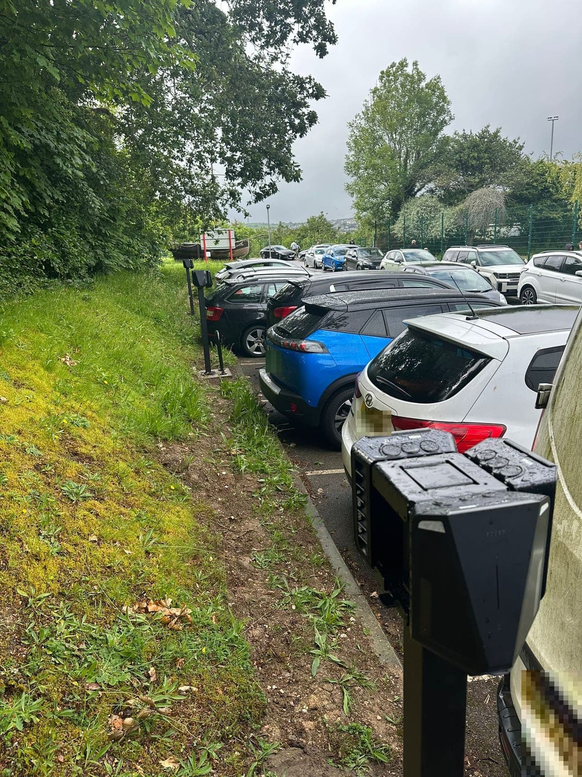 EV chargers lining the staff car park, looking towards the playing fields